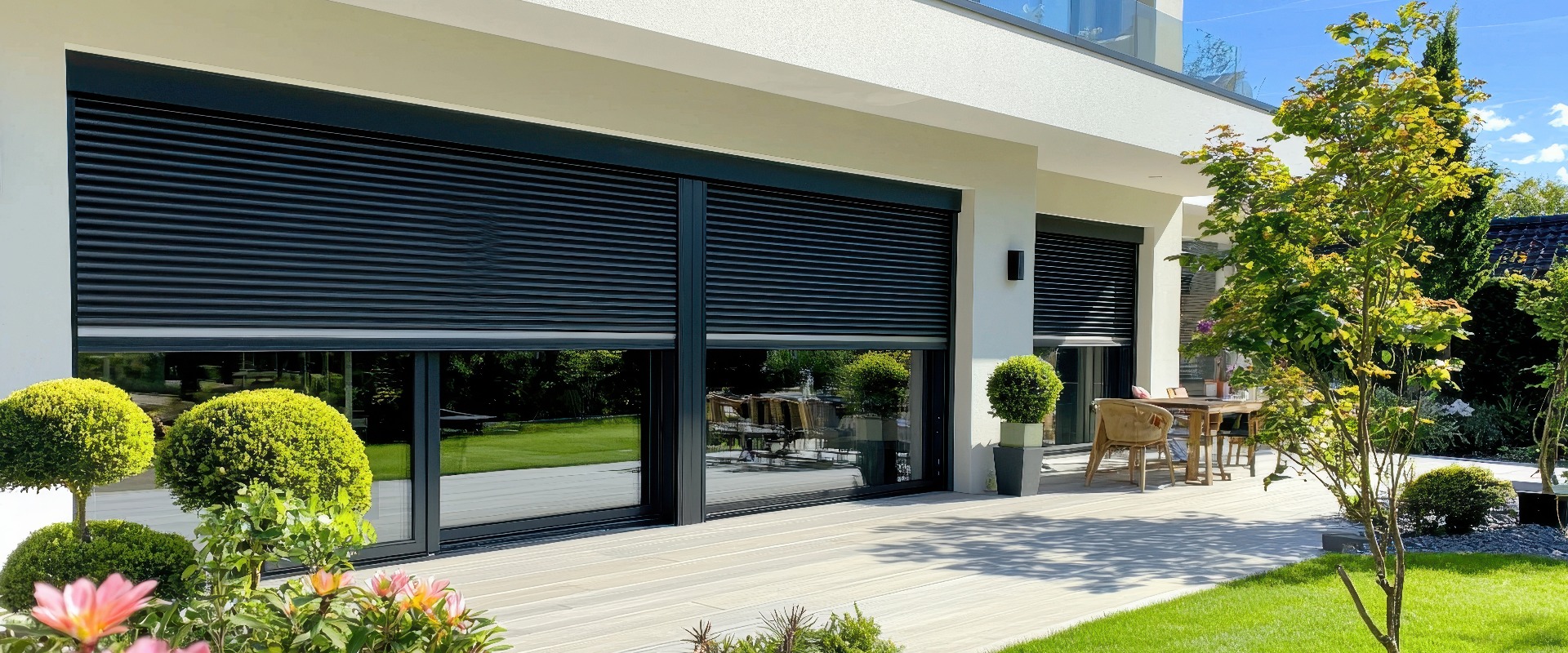 Modernes Haus mit schwarzen Rollläden und Terrasse